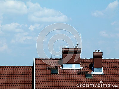 Metal stacks and chimneys on brown clay or concrete tile roof Stock Photo