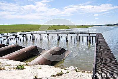 Metal structure of dam, pipes and metal net platform at water storage Stock Photo