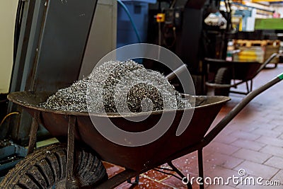 Metal waste from a CNC machine in metal containers. Heavy industry Stock Photo