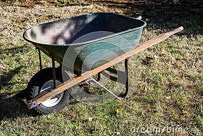 Metal wheelbarrow with a warn out tire, well used gardening tool Stock Photo