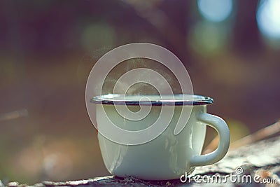 Metal white mug with steam. Forest Stock Photo