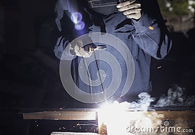 Metal workers use manual labor. Skilled welder. Factory workers making OT. Welder is welding the steel in the factory. Stock Photo