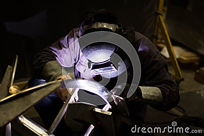 Metal workers use manual labor, Skilled welder, Factory workers making OT, The welder is welding the steel in the factory, Welding Stock Photo