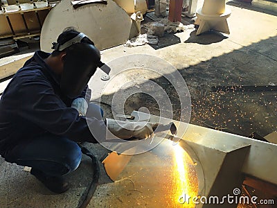 Metal workers use manual labor, The welder is cutting Editorial Stock Photo