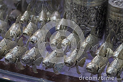 Metallic fishes on market stand, traditional craft of Cambodia. Souvenir shop for tourist. Koi carp metallic figurine Stock Photo