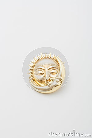 Metallic golden brooch in shape of sun and moon with faces. Spiritual esoteric symbol, astrological boho sign, pin on white Stock Photo