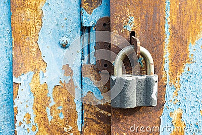 Metallic hanging lock hangs on locked doors of old iron gates Stock Photo