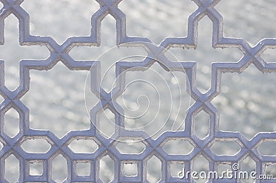 Metallic ornamental fence. Close up on cross, stars shape railing. Dark grey colour on water background. Stock Photo