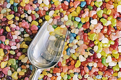 Metallic scoop in colorful candys sweets in confectionery store. Selective fokus. Multicolored background. Top view. Stock Photo