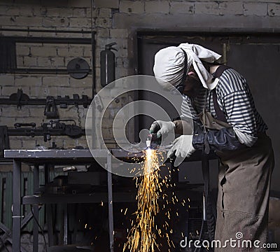 Metalworker cutting on steel plate creating sparks, cutting iron Stock Photo