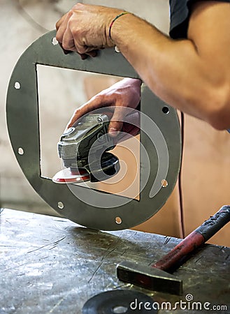 Metalworker sanding a metal component Stock Photo