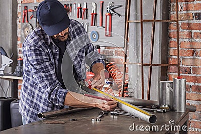 Metalworker taking measurements on a metal pipe Stock Photo