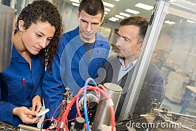 Metalworker with training people using electronic machine Stock Photo