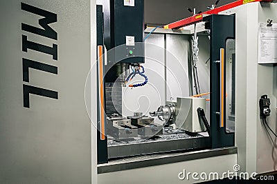 Metalworking CNC lathe milling machine with coolant. Milling apiece of aluminium. Industrial metalworking cutting process on cnc Editorial Stock Photo
