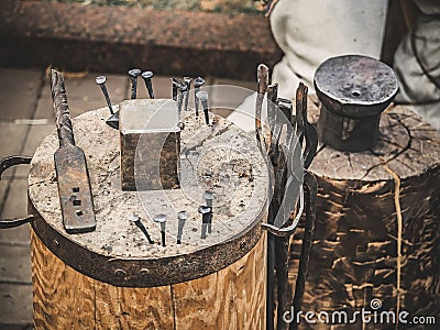 Metalworking tools of blacksmith. The hammer and the anvil and other tools outdoor green grass background. Stock Photo