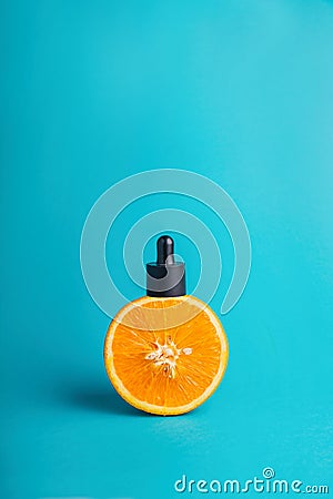 Metaphor, a bottle with a serum, butter in an orange. The concept of vitamin C in cosmetics and aromatherapy Stock Photo