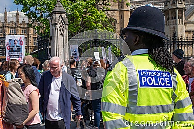 Rear view of black police officer at anti knife crime protest demonstration. Editorial Stock Photo