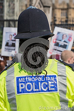Rear view of black police officer at anti knife crime protest demonstration. Editorial Stock Photo