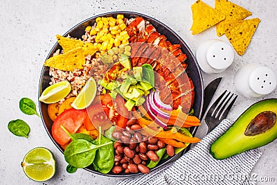 Mexican chicken burrito bowl with rice, beans, tomato, avocado,corn and spinach, top view. Mexican cuisine food concept Stock Photo