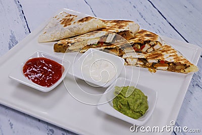 Mexican chicken quesadilla sandwiches and typical condiments Stock Photo