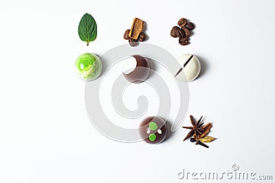 Mexican Colorful chocolate candy bonbons with mint leaves, cinnamon and coffee beans on white background Stock Photo