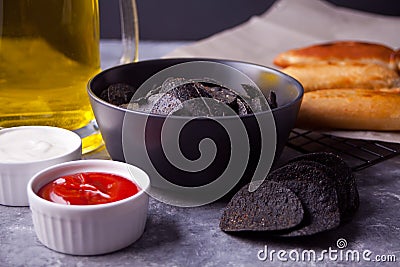 Mexican corn chips nachos and fried meat pies empanadas cheburek with dips. Black chips nachos for brutal men Stock Photo