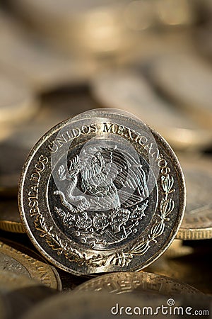 Mexican currency in the foreground, with many more coins in the background Stock Photo