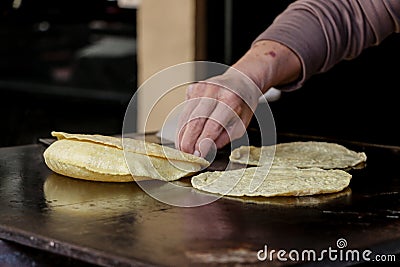 Mexican fresh corn tortillas being cooked on a traditional `comal` Stock Photo