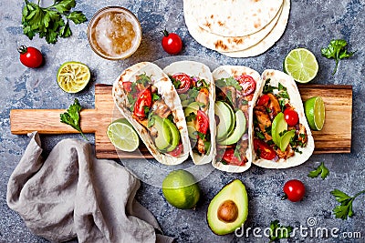 Mexican grilled chicken tacos with avocado, tomato, onion on rustic stone table. Recipe for Cinco de Mayo party. Stock Photo