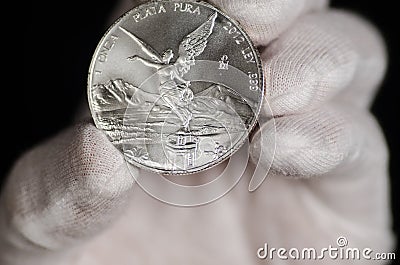 Mexican Libertad Silver Coin hand held Stock Photo