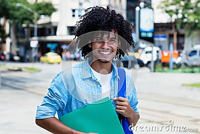 Mexican male student with long curly hair outdoor in city Stock Photo