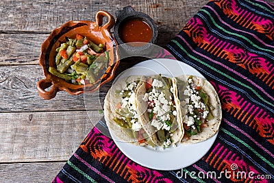 Mexican nopal cactus salad and tacos with cheese on wooden background Stock Photo