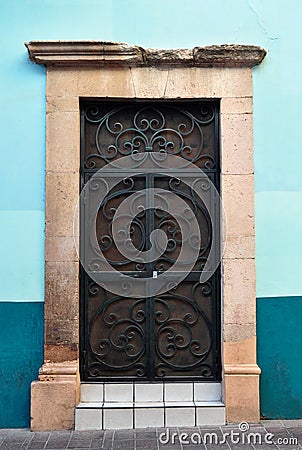 Mexican Rustic Colonial door with metal bars Stock Photo