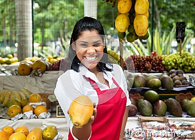 Mexican saleswoman offering fruits on a farmers market Stock Photo