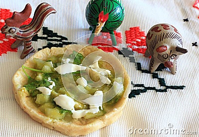 Mexican Salsa Verde Gordita and clay animal figurines Stock Photo