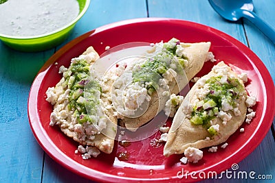 Mexican tlacoyos with green sauce on blue background Stock Photo