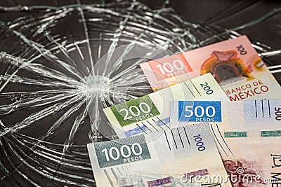 Mexico Money, Pesos Problems, Weakening of Mexican Currency, Bundle of Mexican Money on Broken Glass Background, Stock Photo