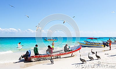 Mexico, Playa del Carmen - January 11, 2019: Tourists, locals and wild pelicans on a public beach on the Caribbean coast. Editorial Stock Photo