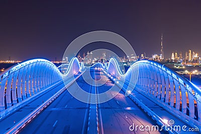 Meydan Bridge and street road or path way on highway with modern architecture buildings in Dubai Downtown at night, urban city at Stock Photo