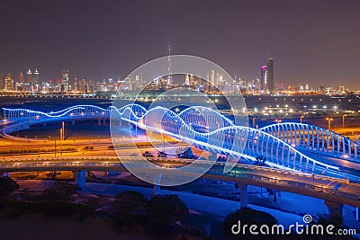 Meydan Bridge and street road or path way on highway with modern architecture buildings in Dubai Downtown at night, urban city at Stock Photo