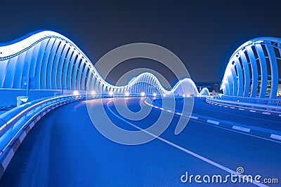 Meydan Bridge and street road or path way on highway with modern architecture buildings in Dubai Downtown at night, urban city at Stock Photo