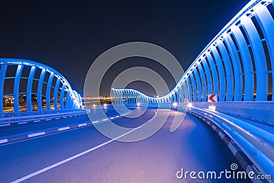 Meydan Bridge and street road or path way on highway with modern architecture buildings in Dubai Downtown at night, urban city at Stock Photo