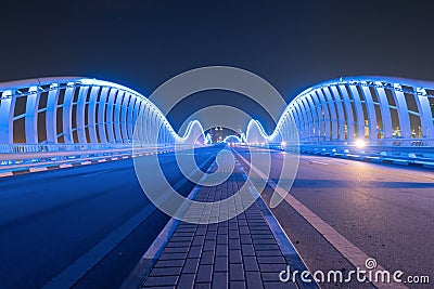 Meydan Bridge and street road or path way on highway with modern architecture buildings in Dubai Downtown at night, urban city at Stock Photo