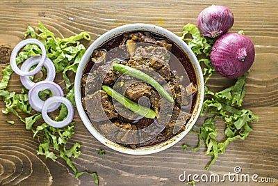 Mezbani Gosht, achar goshat, beef masala karahi, rogan josh with onion, pepper and salad served in a dish isolated on wooden table Stock Photo