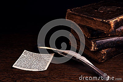 Mezuzah with Jewish prayer Shema Yisrael in hebrew with Biblical commandment, quill and stack of shabby old jewish books Stock Photo