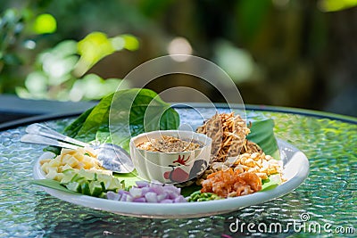 Miang kham â€“ A royal leaf wrap appetizer, is a traditional Southeast Asian snack from Thailand and Laos. It`s on the white dish Stock Photo