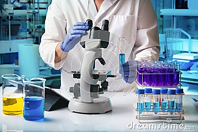 Microbiologist scientist analyzing a sample under a microscope in the science lab Stock Photo