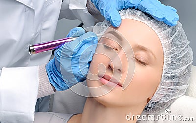 Microblading. Cosmetologist making permanent makeup. Attractive woman getting facial care and tattoo eyebrows Stock Photo