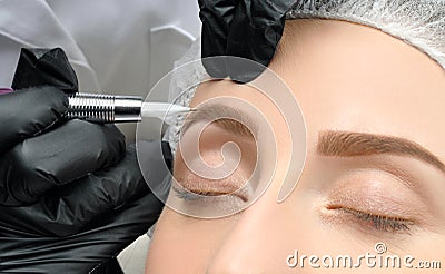 Microblading. Cosmetologist making permanent makeup. Attractive woman getting facial care and tattoo eyebrows Stock Photo