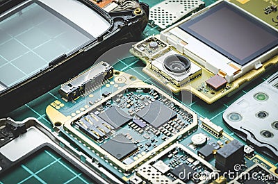 Microchips, semiconductor components and precious metals on the Board of the disassembled old mobile phone close-up Stock Photo